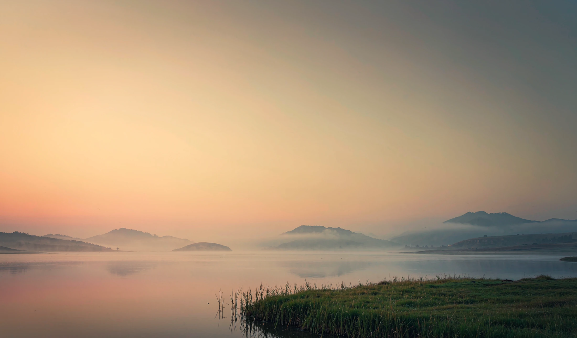 Serene misty mountain lake at dawn — calm, open space